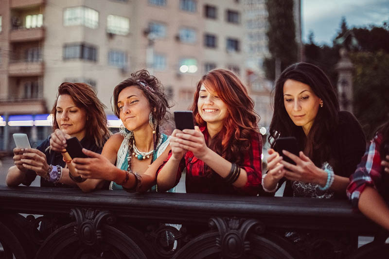 Phone addicted girls texting in the city