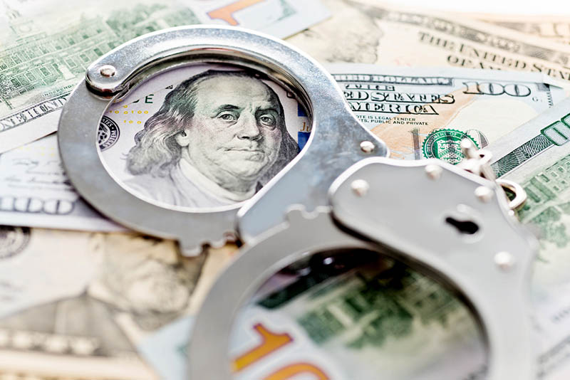 Handcuffs lying on american dollars