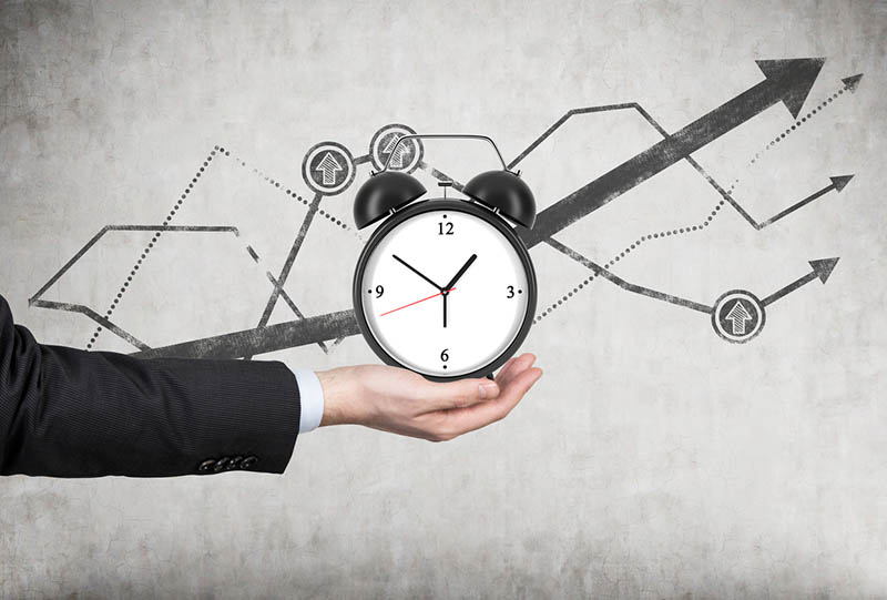 businessman's hand holds an alarm clock.