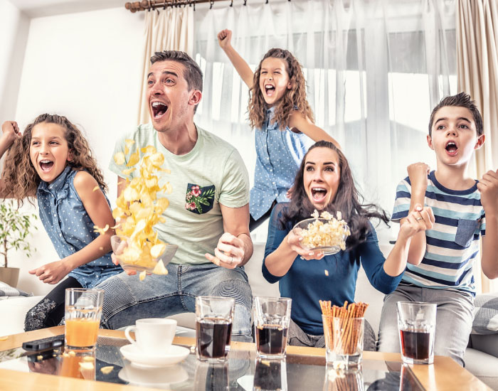 A family excitedly watches the live broadcast of contest results